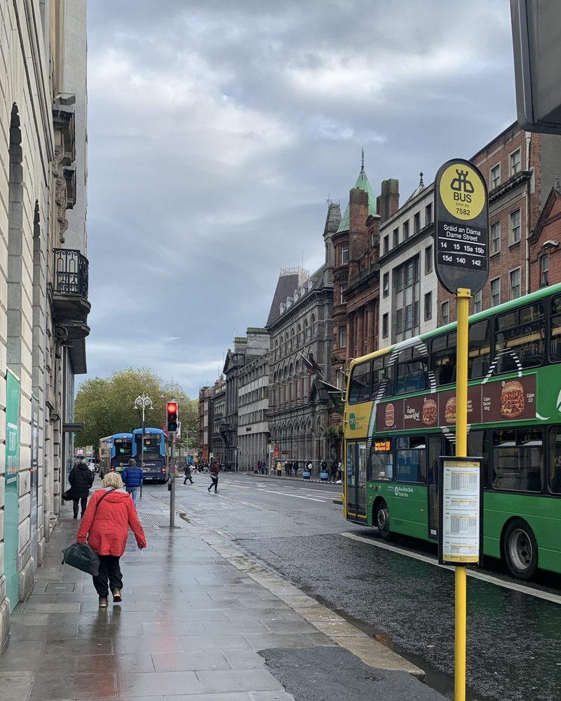 A wet Dame Street, red coat and a green double-decker