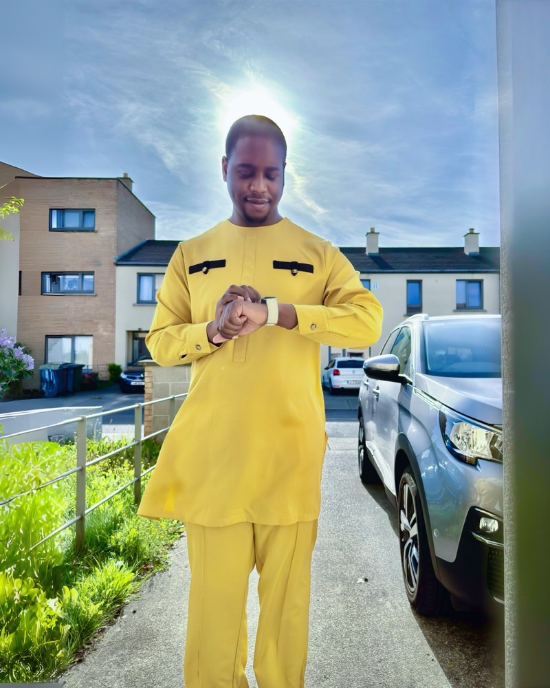 Yellow two-piece on a sunlit driveway, checking the time